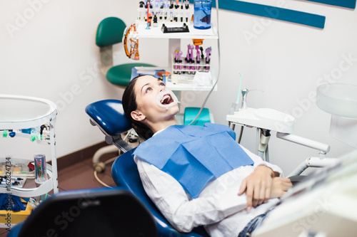 The girl patient with a retractor at the dentist office