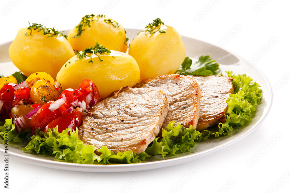 Grilled pork chops, boiled potatoes and vegetable salad Grilled pork chops, boiled potatoes and vegetable salad