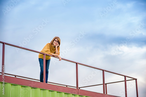 Portrait woman smiling while standing with her hand on her chin..Portrait woman smiling while standing on terrace.