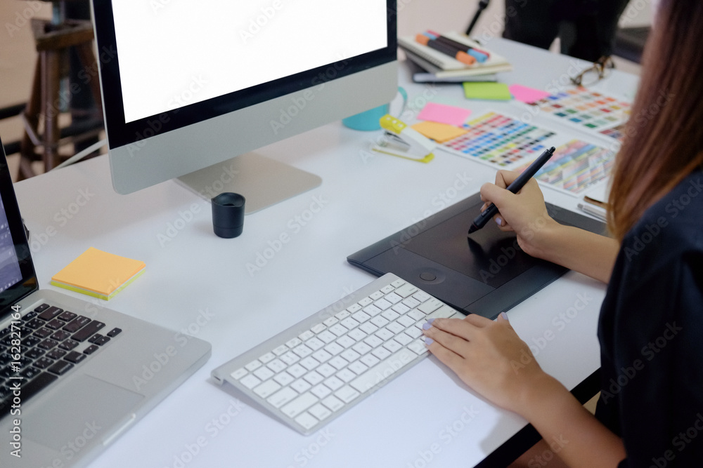 Young photographer and graphic designer at work in office. Blank screen monitor for graphic display montage. Young photographer and graphic designer at work in office. Blank screen monitor for graphic display montage.