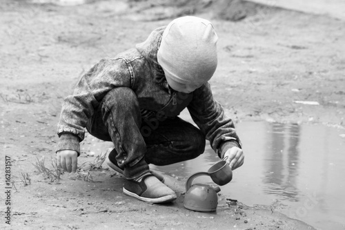 little boy playing with water and sand at the playground