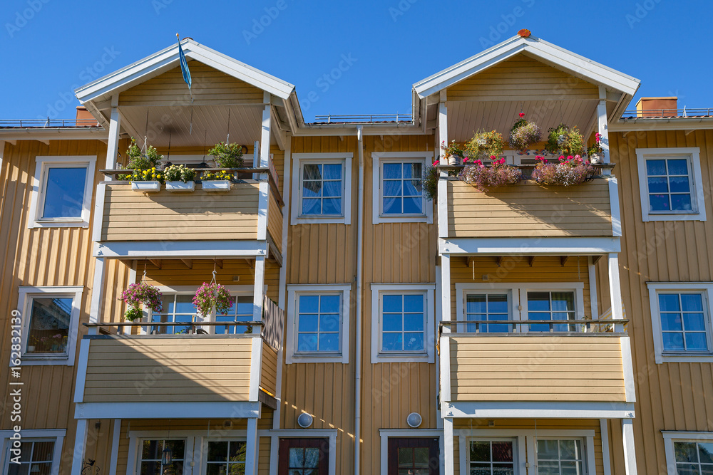 Modern wooden house (block) with balconies and flowers