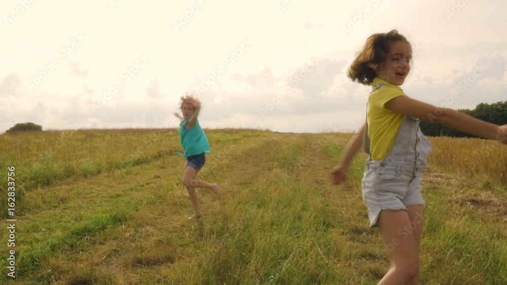 Young Girls Playing With Bubble Blower in Wheat Field Young Girls Playing With Bubble Blower in Wheat Field