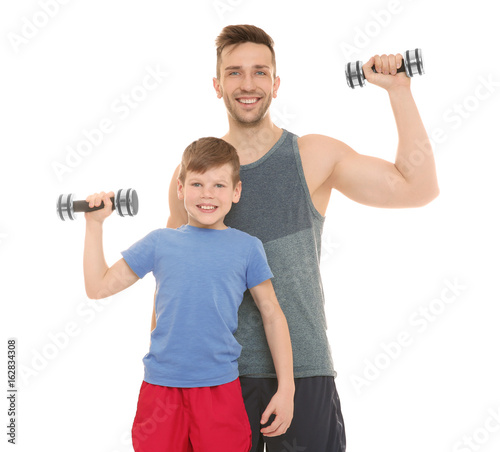 Happy dad and son with dumbbells in hands on white background