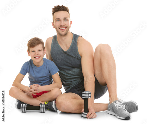 Dad and son sitting with du...