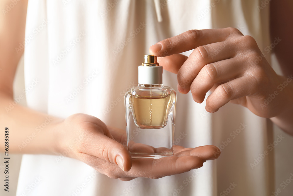 Female hands holding perfume bottle foto de Stock | Adobe Stock