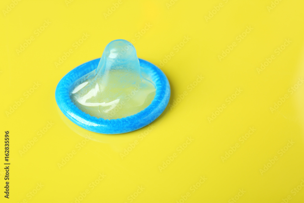 Blue condom on color background. Safe sex concept