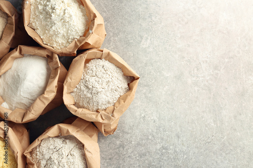 Obraz na plátně Paper bags with different types of flour on table