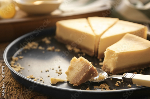 Tray with cheese cake pieces and spoon on kitchen table