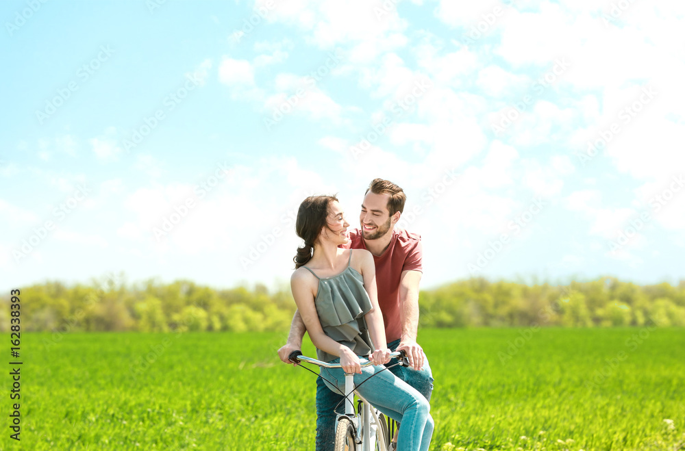 Happy young couple riding bicycle in countryside Happy young couple riding bicycle in countryside