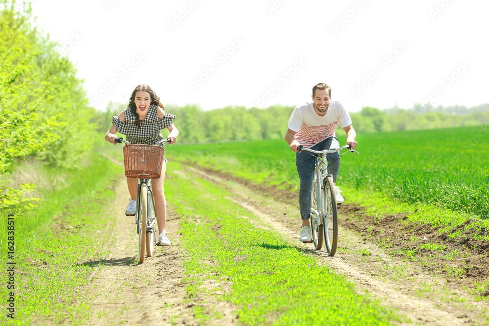 Happy young couple riding bicycles in countryside Happy young couple riding bicycles in countryside
