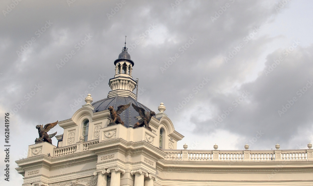 beautiful old building with gargoyles on a background of dark sky with storm clouds