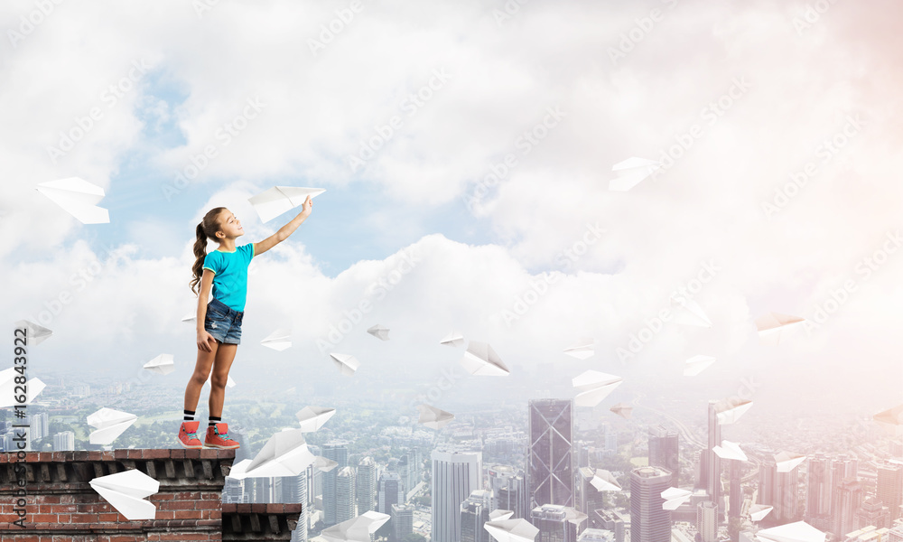Concept of careless happy childhood with girl dreaming to become pilot Concept of careless happy childhood with girl dreaming to become pilot