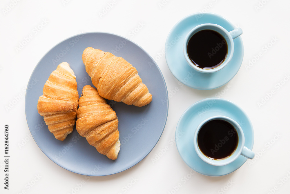 cup of coffee with croissant on white background