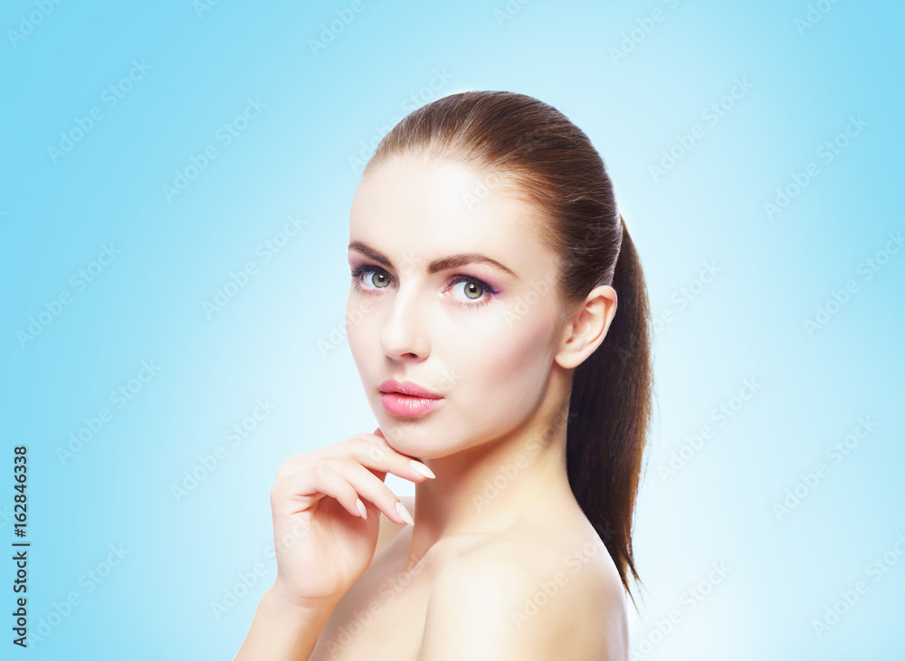 Portrait of young, beautiful and healthy woman: over cyan background. Healthcare, spa, makeup and face lifting concept. Portrait of young, beautiful and healthy woman: over cyan background. Healthcare, spa, makeup and face lifting concept.