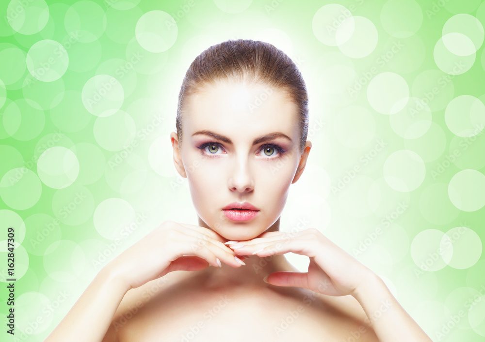 Naklejka premium Portrait of young, beautiful and healthy woman: over green background. Healthcare, spa, makeup and face lifting concept.
