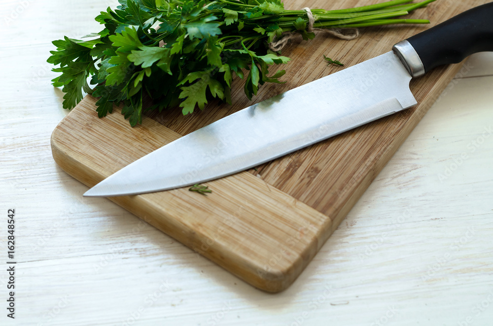 Fresh organic parsley with knife on wooden cutting board. Fresh organic parsley with knife on wooden cutting board.