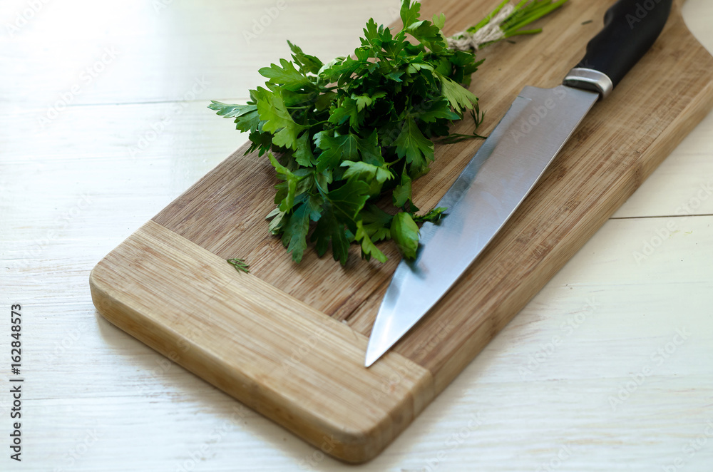 Fresh organic parsley with knife on wooden cutting board. Fresh organic parsley with knife on wooden cutting board.