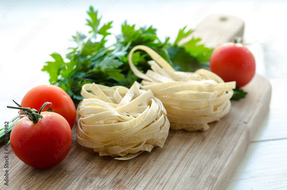 Ingredients for cooking Italian pasta - spaghetti, tomatoes, basil and garlic. Ingredients for cooking Italian pasta - spaghetti, tomatoes, basil and garlic.