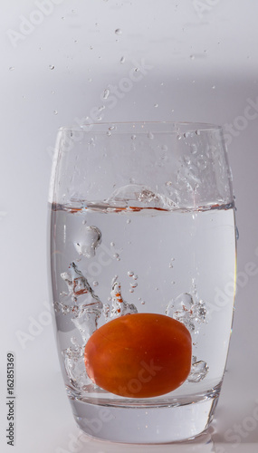 Blasen im Wasser durch fallende Tomaten