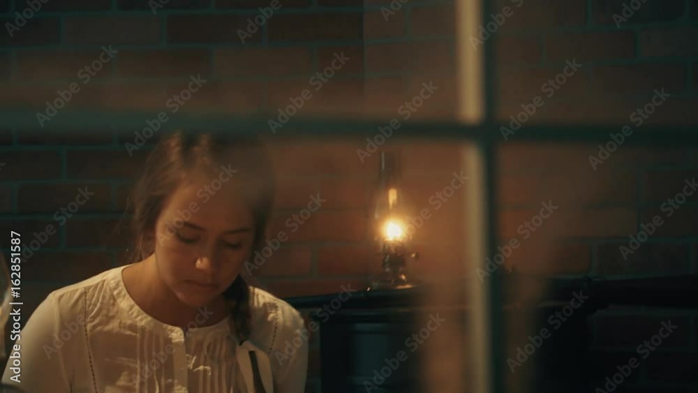 old west woman walks in and reads a book. POV from outside of house.