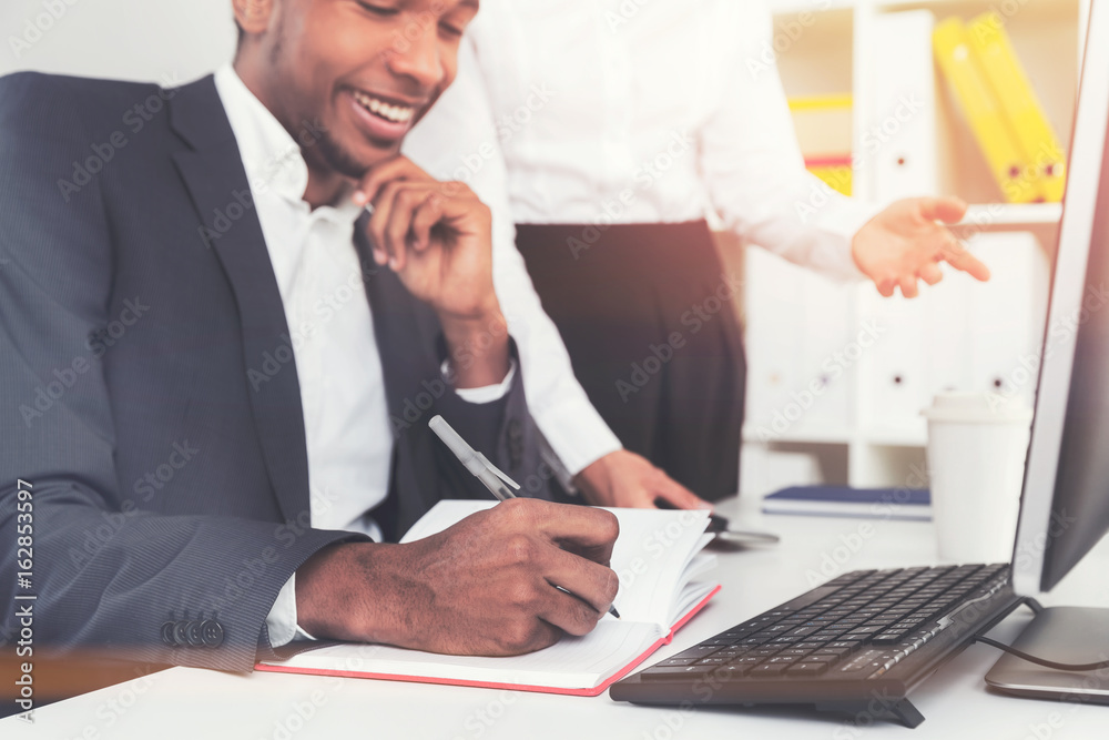 Smiling African American businessman writing Smiling African American businessman writing