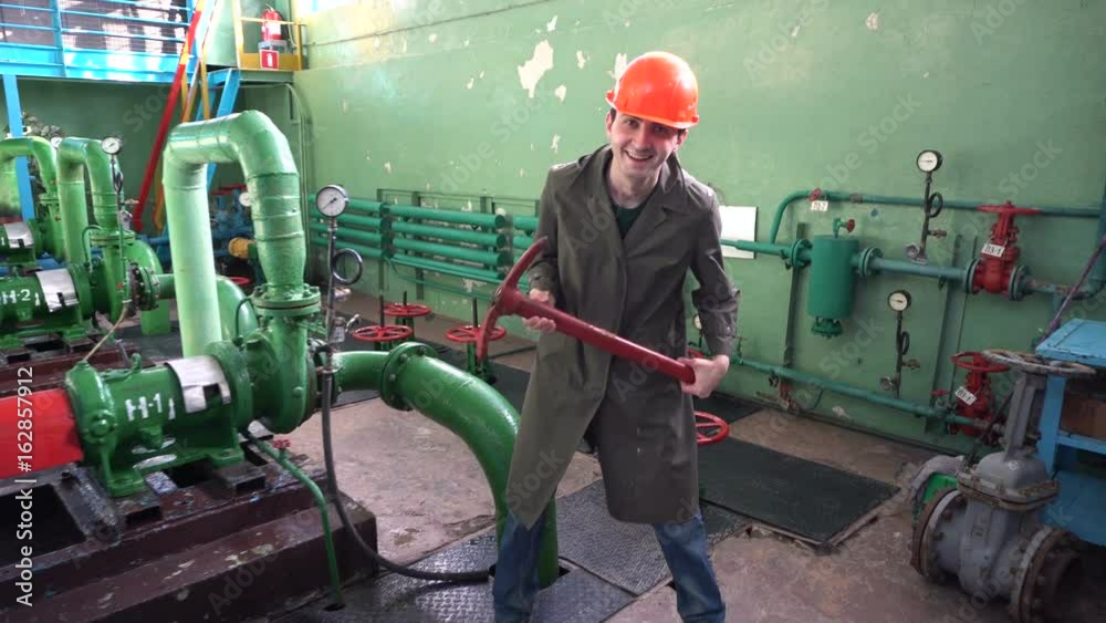 crazy maniac-engineer holds a pickaxe and hysterically laughing on the factory crazy maniac-engineer holds a pickaxe and hysterically laughing on the factory