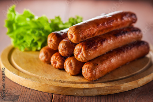 Fried sausages on a wooden tray