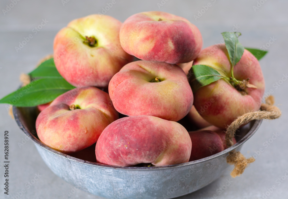 Fresh ripe chinese flat saturn peaches with leaves Fresh ripe chinese flat saturn peaches with leaves