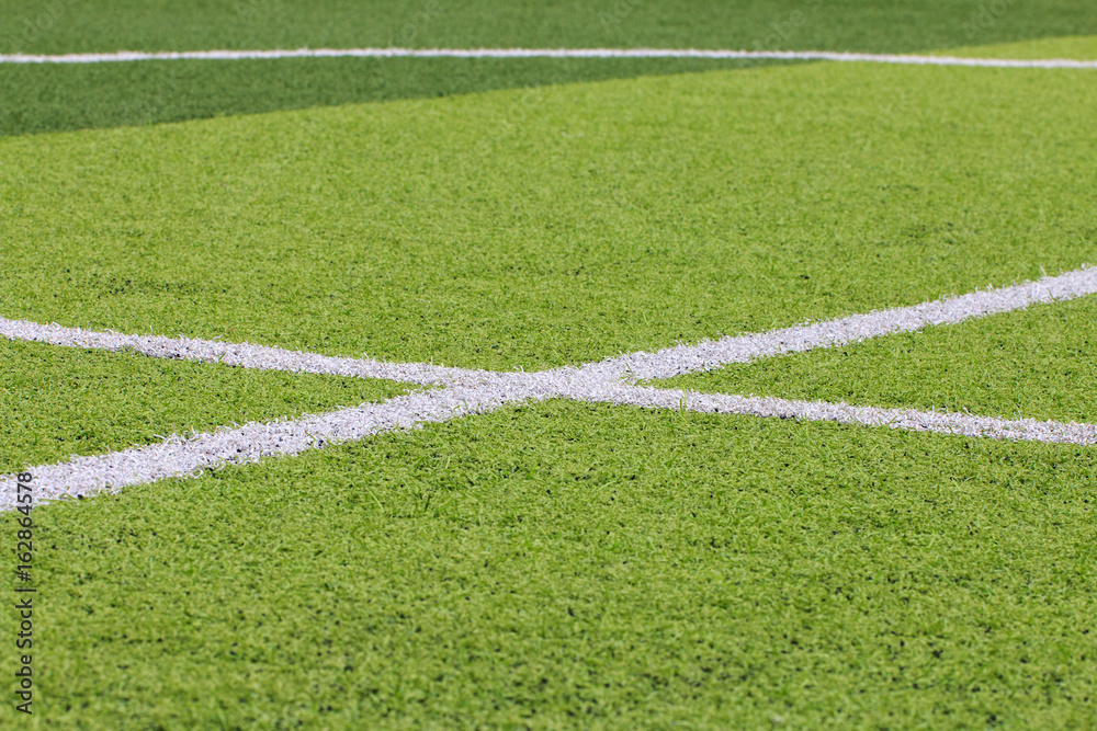 Obraz premium Photo of a green synthetic grass sports field with white line shot from above.