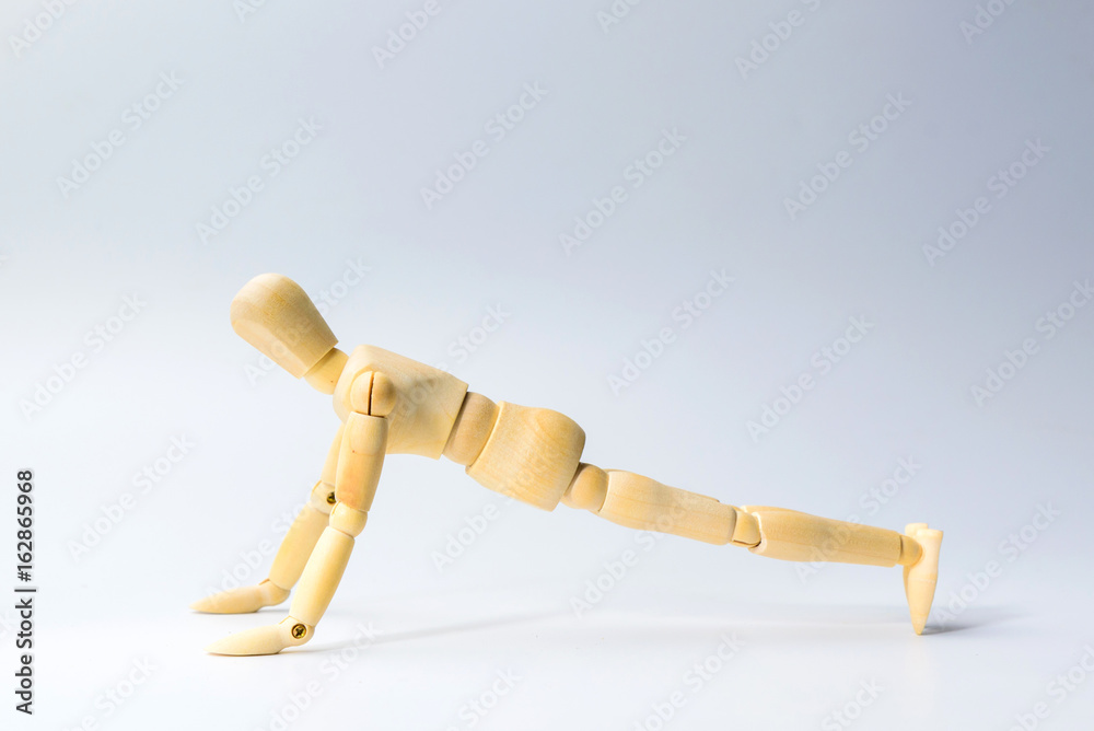 Wooden figure doll with push up for health on white for exercise training and helth concept Wooden figure doll with push up for health on white for exercise training and helth concept
