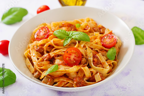 Pasta Fettuccine Bolognese with tomato sauce in white bowl.