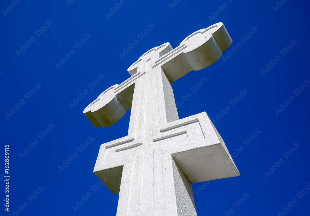 White orthodox christian cross on blue sky background.
