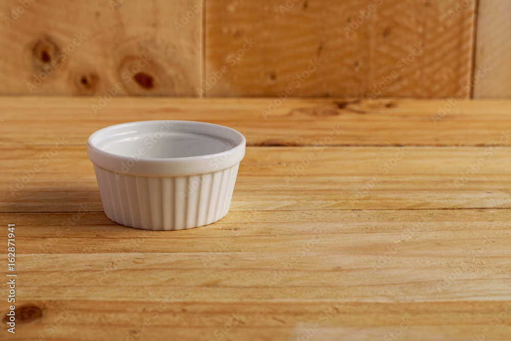 white ceramic bowl on wooden table white ceramic bowl on wooden table