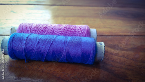 colorful sewing threads on wood background