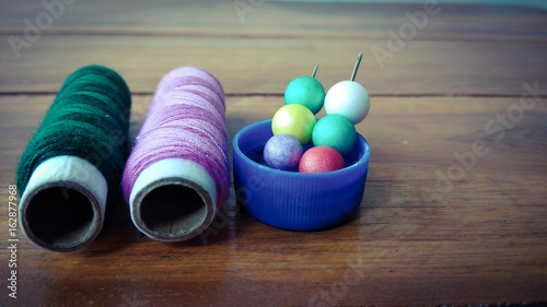 colorful sewing threads with colorful bubbles on wood background