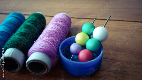 colorful sewing threads with colorful bubbles on wood background
