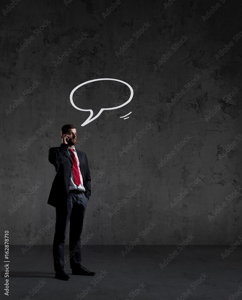 Businessman talking on the phone over dark dramatic background. Business and office, concept. Businessman talking on the phone over dark dramatic background. Business and office, concept.