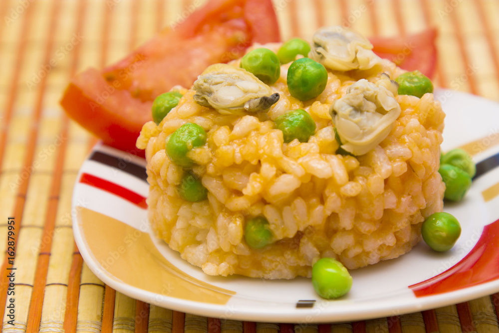 rice with clams accompanied by tomato. rice with clams accompanied by tomato.