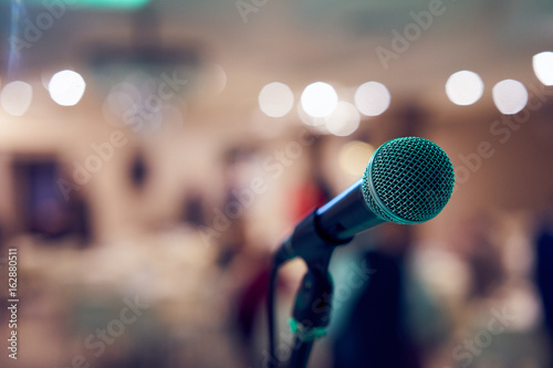 Obraz na plátne Microphone in concert hall or conference room with defocused bokeh lights in background