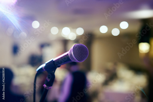 Microphone in concert hall or conference room with defocused bokeh lights in background. Extremely shallow dof. : Vintage style and filtered process