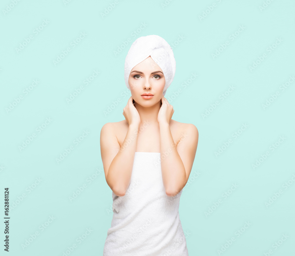 Young, beautiful and natural woman wrapped in towel over cyan background. Young, beautiful and natural woman wrapped in towel over cyan background.