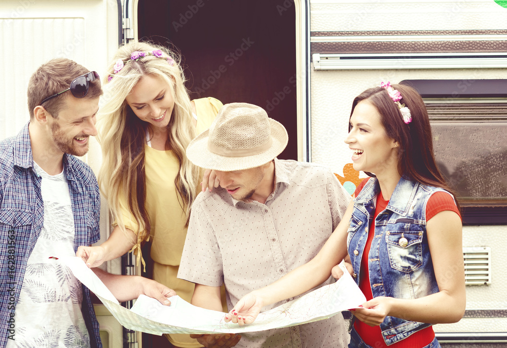 Happy friends checking the map and planning their route. Trip, traveling, holiday, vacation concept. Happy friends checking the map and planning their route. Trip, traveling, holiday, vacation concept.