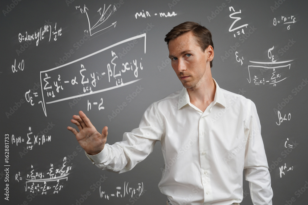 Man scientist or student working with various high school maths and science formulas.