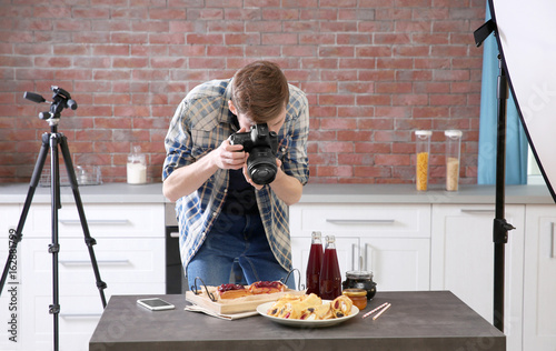 Young man photographing food in photo studio photo