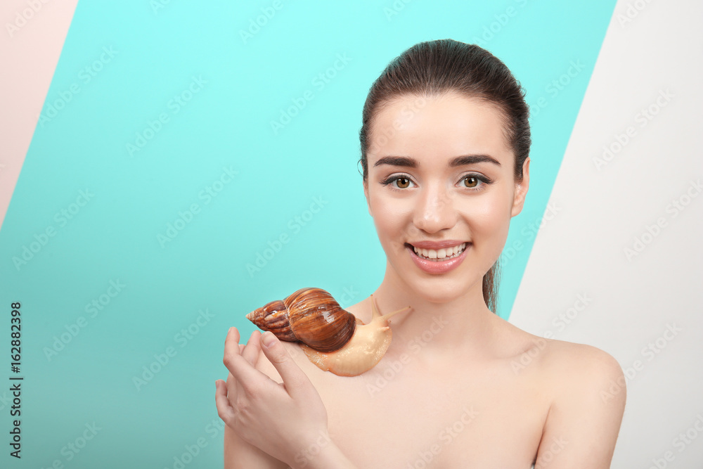 Beautiful young woman with giant Achatina snail on color background Beautiful young woman with giant Achatina snail on color background