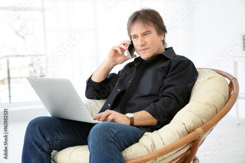 Mature man talking on phone...