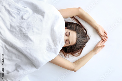 Young woman lying in bed