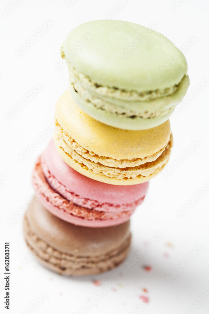 Staple of colorful macarons on white background