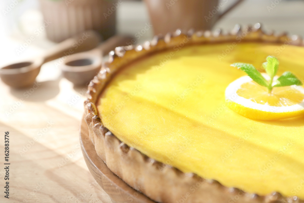 Wooden plate with tasty lemon curd pie on table, closeup Wooden plate with tasty lemon curd pie on table, closeup